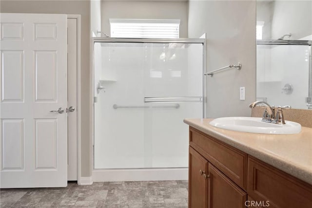 bathroom with vanity and a shower with door