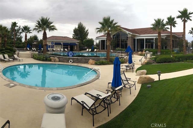 view of swimming pool with a lawn and a patio