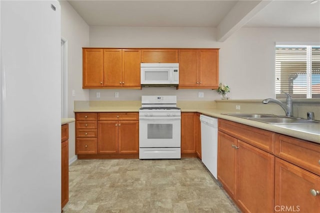 kitchen with white appliances, beam ceiling, and sink