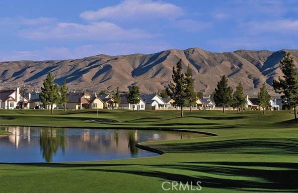 view of property's community featuring a water and mountain view and a yard