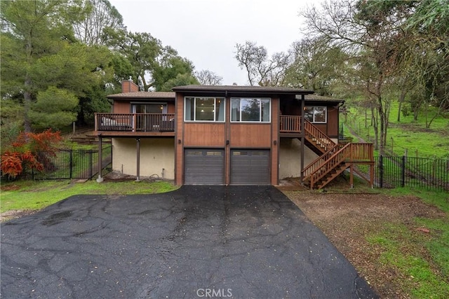 view of front of home with a wooden deck and a garage