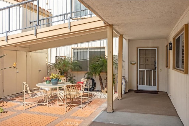 view of exterior entry with a balcony and a patio area