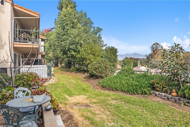 view of yard featuring a balcony and a mountain view