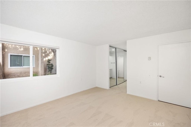 unfurnished bedroom featuring light colored carpet and a closet