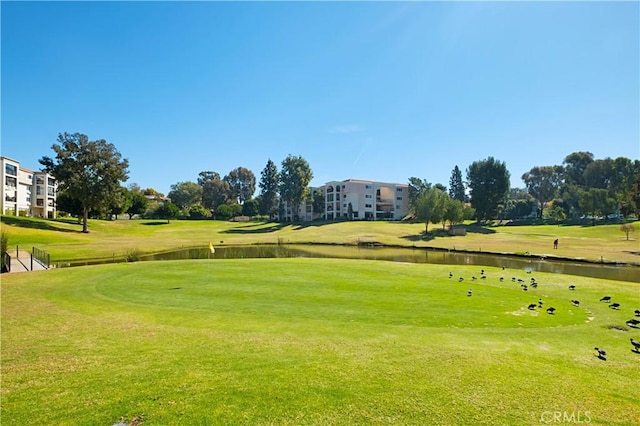 view of community featuring a water view and a yard