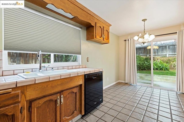 kitchen featuring sink, light tile patterned floors, dishwasher, hanging light fixtures, and tile counters