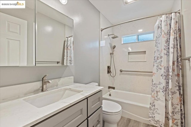 full bathroom with hardwood / wood-style flooring, vanity, shower / bath combo, and toilet