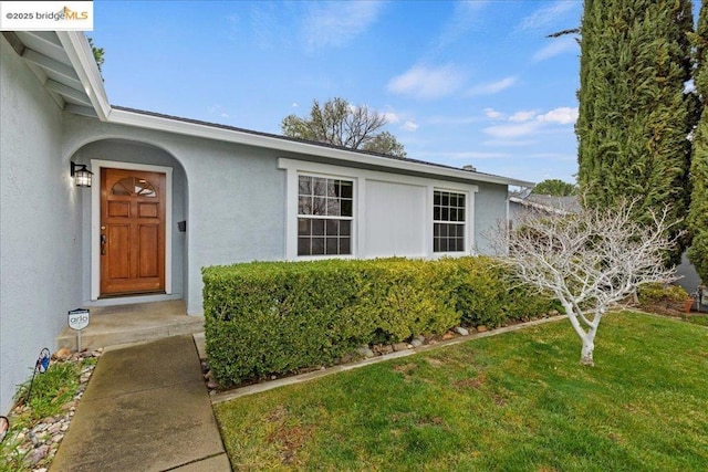 entrance to property with a lawn