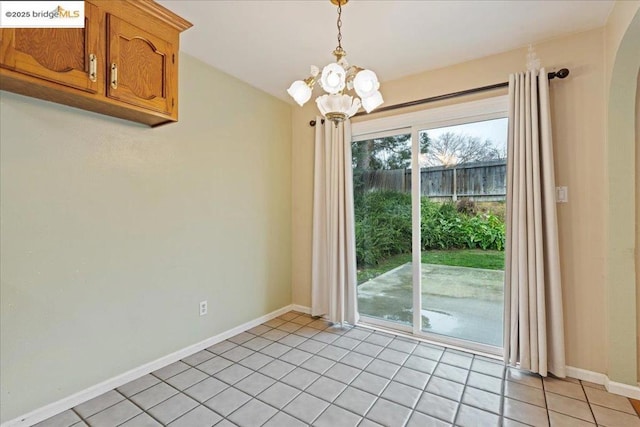 unfurnished dining area with a chandelier and light tile patterned floors