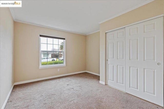 unfurnished bedroom with crown molding, carpet, and a closet