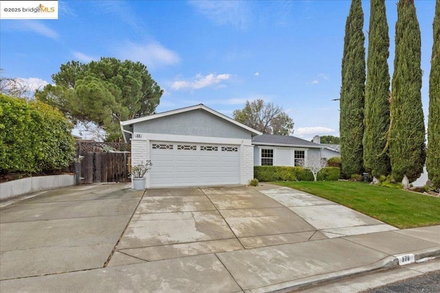 single story home featuring a garage and a front lawn