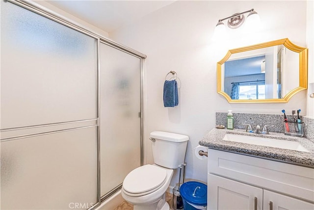 bathroom featuring vanity, toilet, and a shower with door