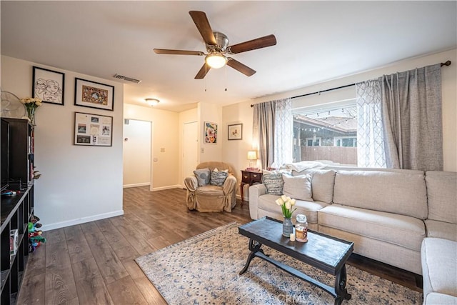 living room featuring dark wood-type flooring and ceiling fan