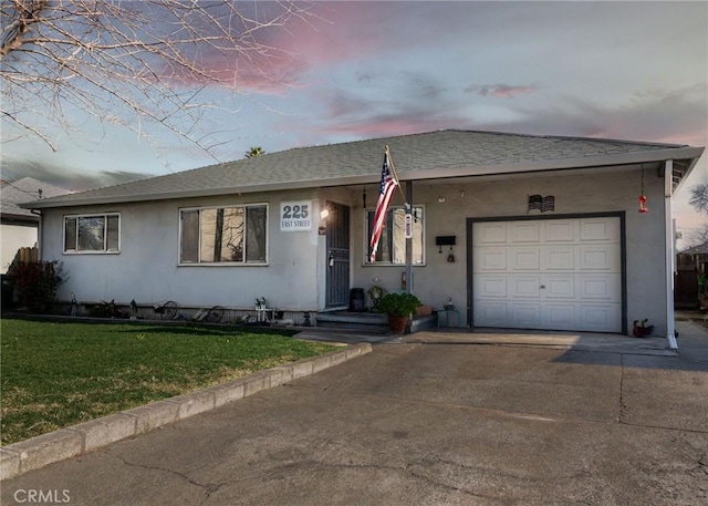 ranch-style home with a garage and a lawn