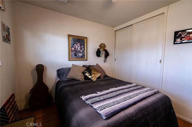 bedroom featuring dark wood-type flooring and a closet