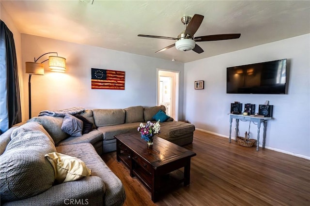 living room featuring dark wood-type flooring and ceiling fan