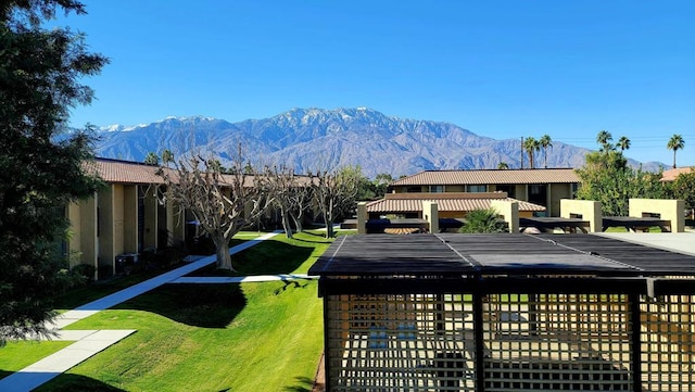 view of home's community with a mountain view and a yard