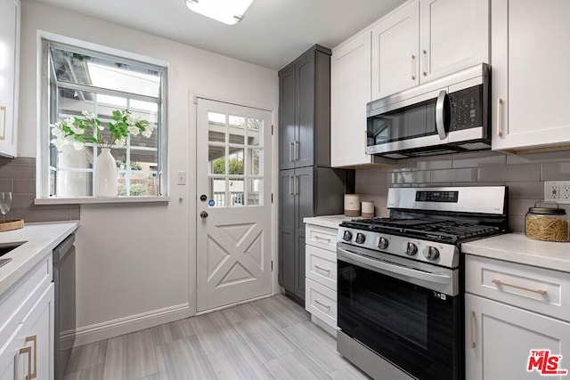 kitchen with white cabinetry, appliances with stainless steel finishes, and tasteful backsplash