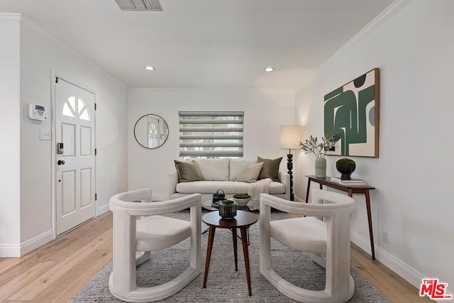 living room with ornamental molding and light wood-type flooring