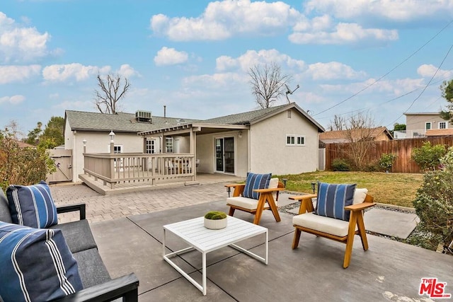 back of property with a wooden deck, outdoor lounge area, and a patio