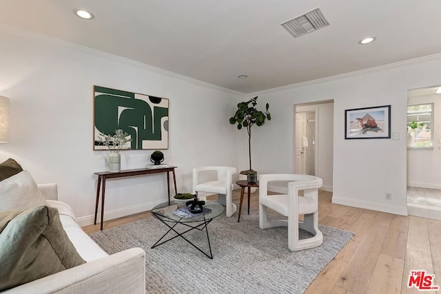 living room with crown molding and light hardwood / wood-style flooring