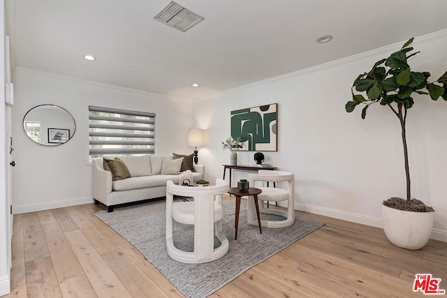 living room featuring ornamental molding and light wood-type flooring