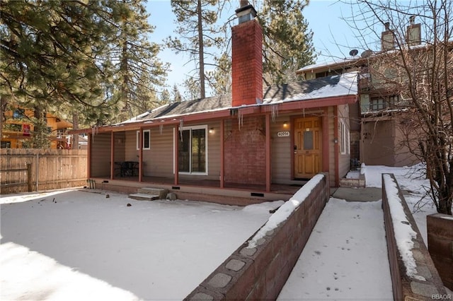 view of snow covered back of property