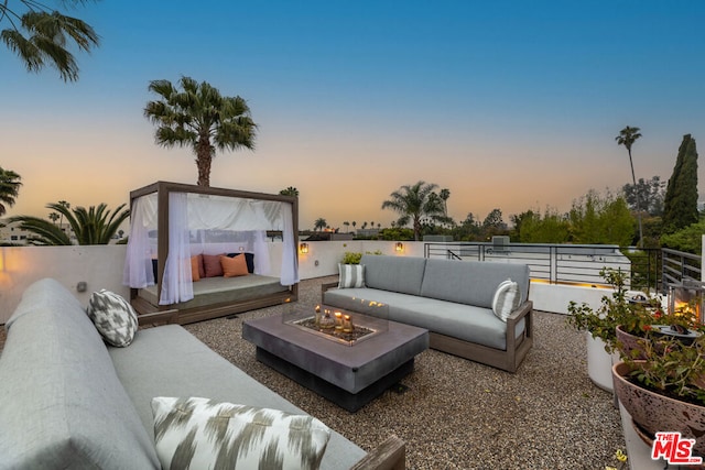 patio terrace at dusk featuring an outdoor living space with a fire pit