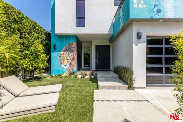 doorway to property featuring a yard