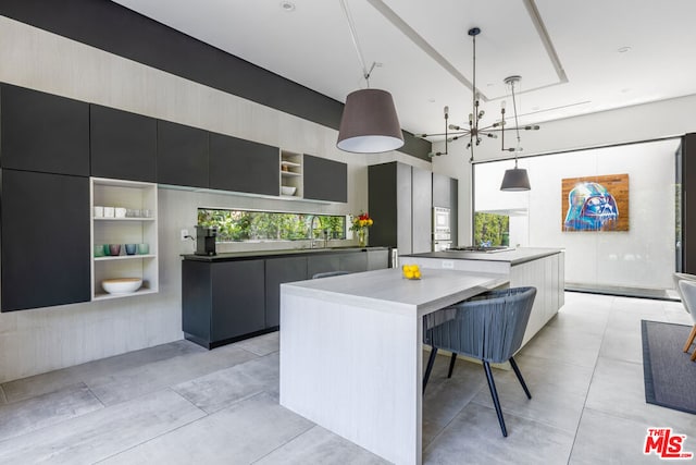 kitchen with fridge, a healthy amount of sunlight, a large island, and hanging light fixtures