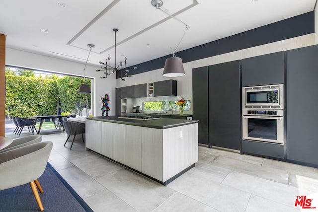 kitchen with a kitchen island, appliances with stainless steel finishes, and decorative light fixtures