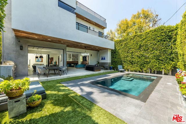 rear view of property with a balcony, an outdoor hangout area, and a patio area