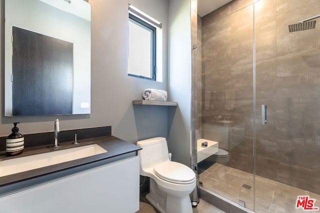 bathroom featuring vanity, an enclosed shower, and toilet