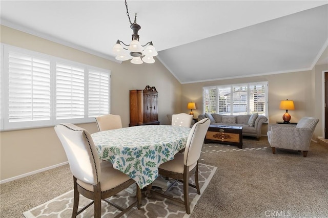 carpeted dining area with lofted ceiling, ornamental molding, and an inviting chandelier