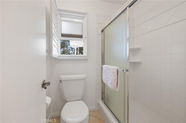 bathroom with tile patterned flooring, toilet, and walk in shower