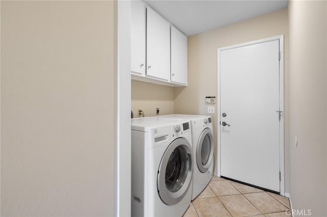 laundry area featuring cabinets, washer and dryer, and light tile patterned floors