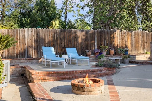 view of patio featuring central air condition unit and an outdoor fire pit