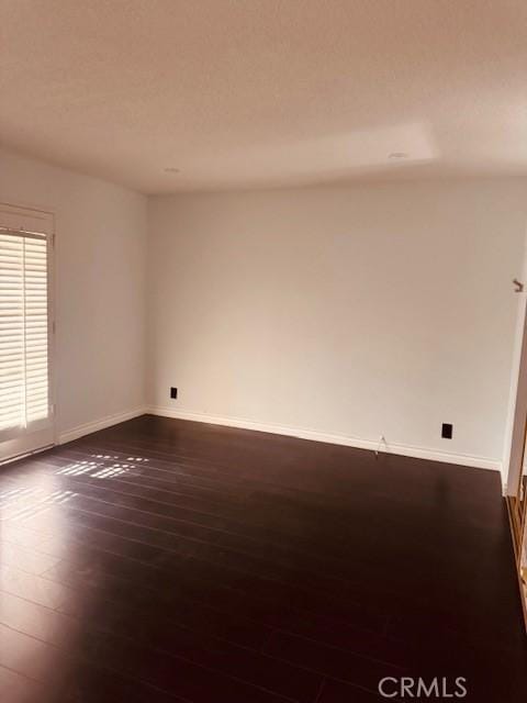 unfurnished room with dark hardwood / wood-style floors