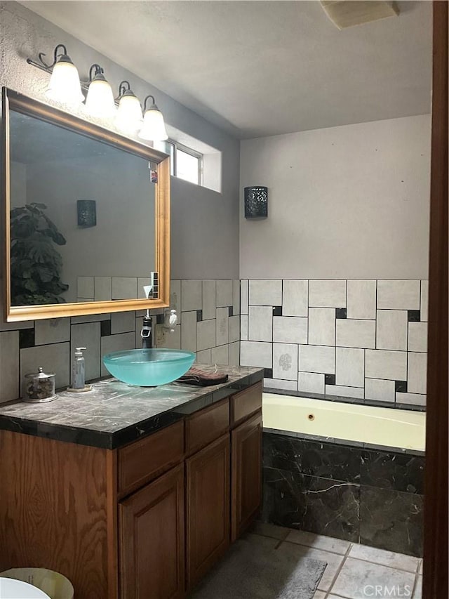 bathroom with vanity, tiled bath, and tile patterned floors