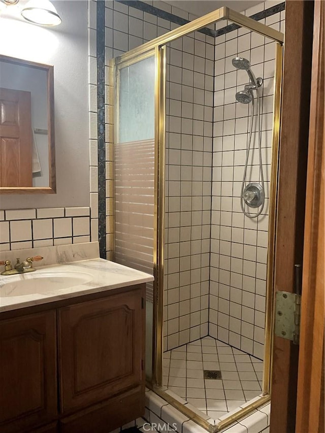 bathroom featuring vanity, decorative backsplash, and walk in shower