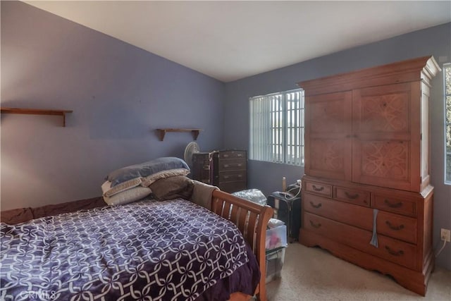 bedroom with lofted ceiling and light carpet