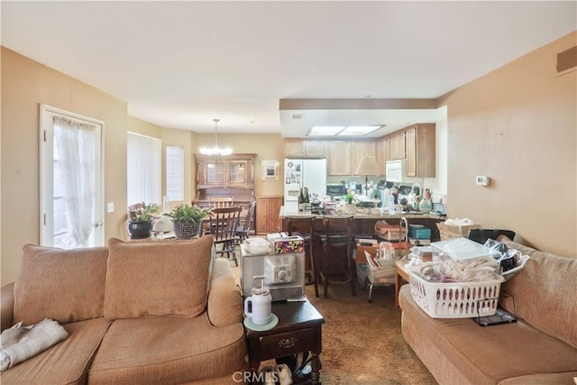 carpeted living room with a notable chandelier