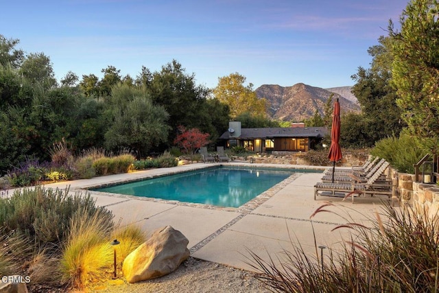 view of pool with a patio and a mountain view