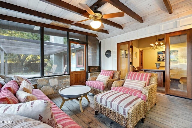 sunroom featuring beamed ceiling, ceiling fan with notable chandelier, and wood ceiling