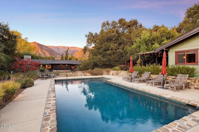 view of swimming pool with a mountain view and a patio