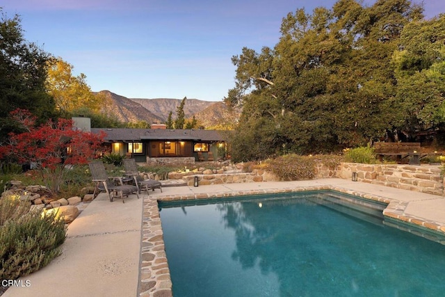 view of swimming pool featuring a mountain view and a patio area