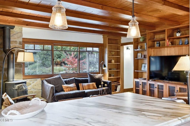 living room with beam ceiling, wood ceiling, built in shelves, and a wood stove