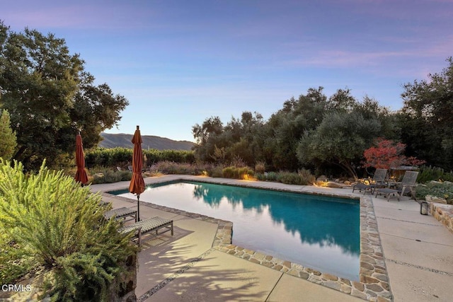 view of pool with a mountain view and a patio