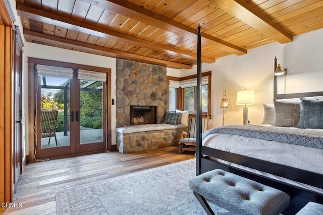 bedroom with wooden ceiling, a fireplace, light hardwood / wood-style flooring, and access to outside