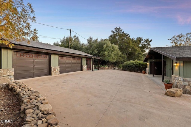 garage at dusk featuring solar panels